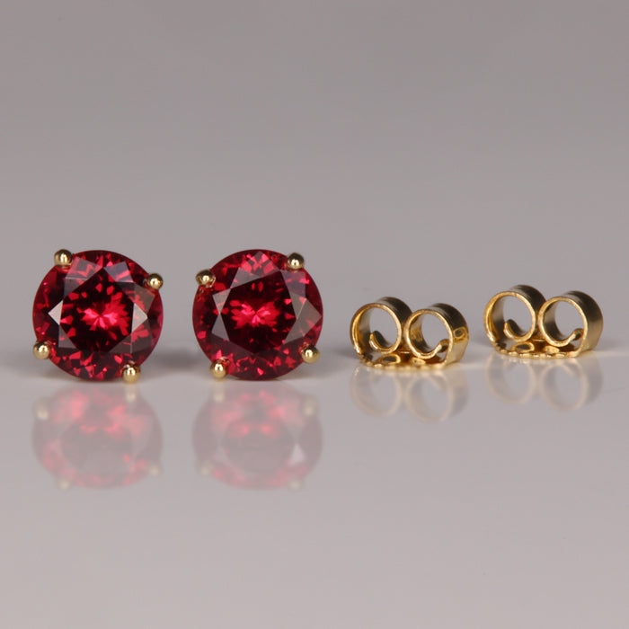 violet red garnet gemstone earrings in yellow gold