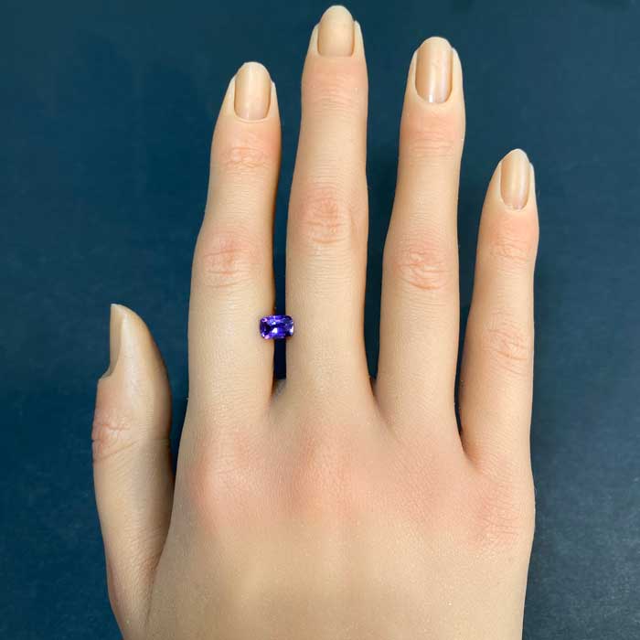 purple sapphire gem on hand