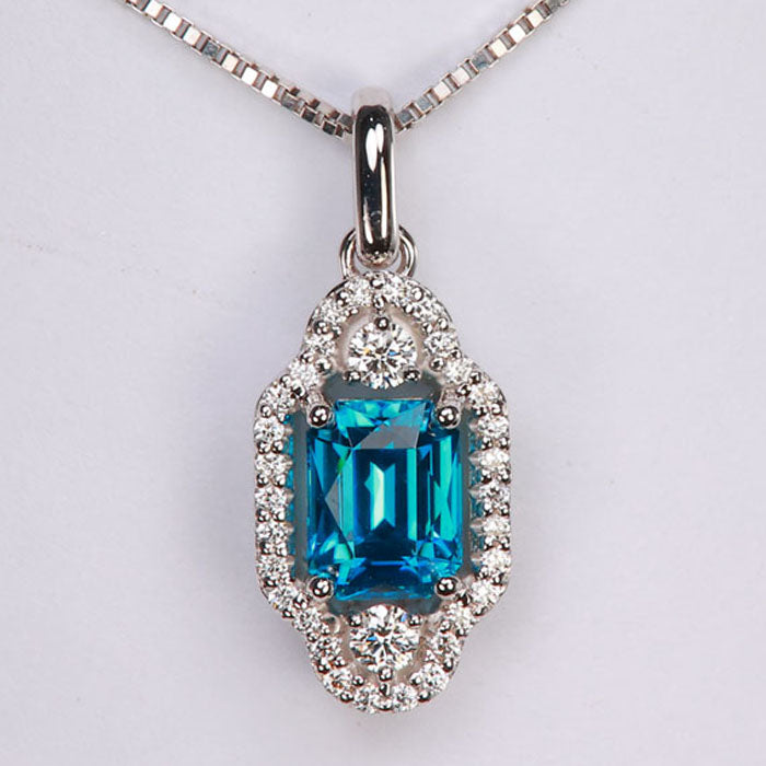 emerald cut blue zircon gemstone with diamond accents in a white gold pendant