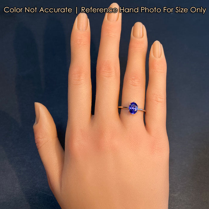 oval cut tanzanite ring with diamond accents on hand