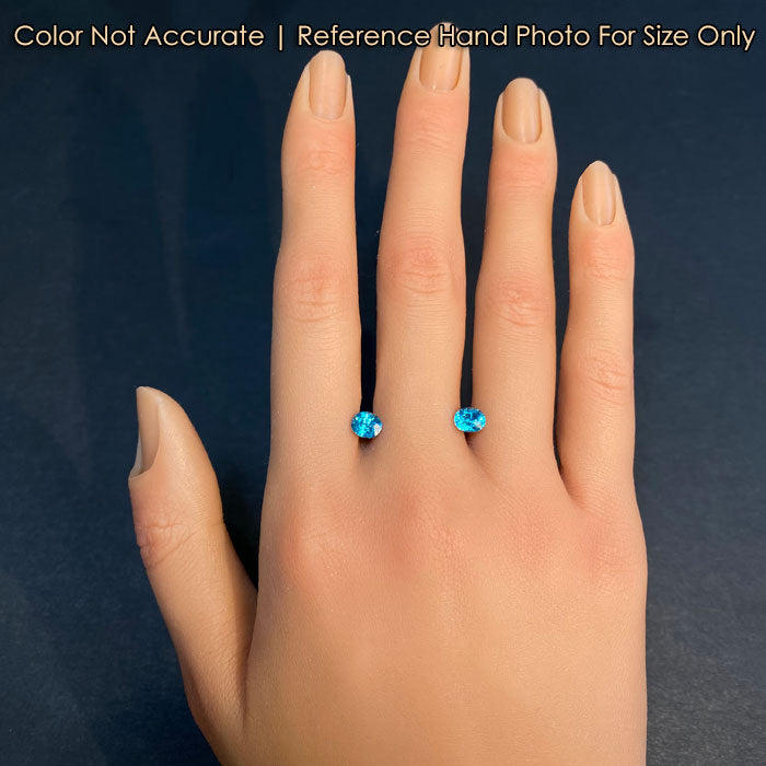 oval cut blue zircon gems on hand