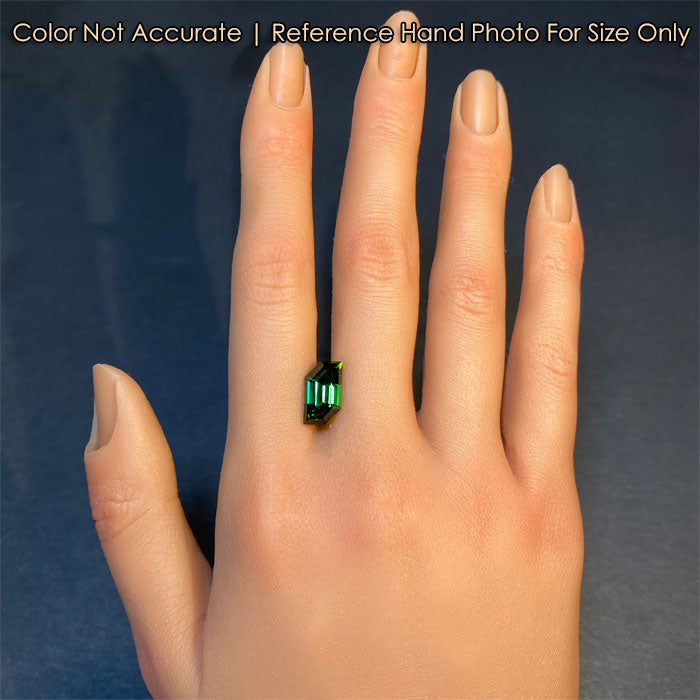 green color tourmaline gemstone on hand
