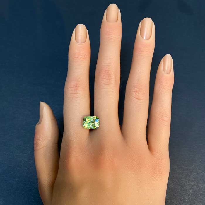 green sphene gemstone on hand 