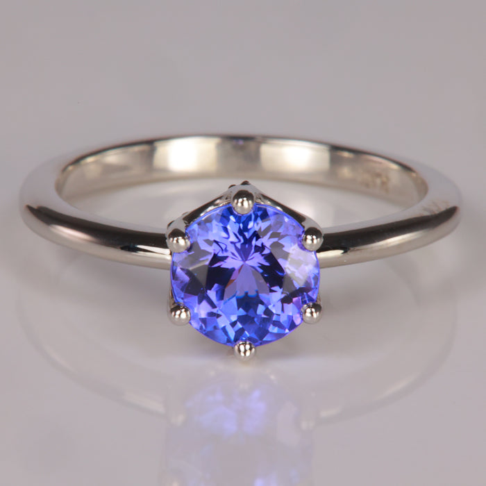 round tanzanite gem in platinum ring with diamond accents