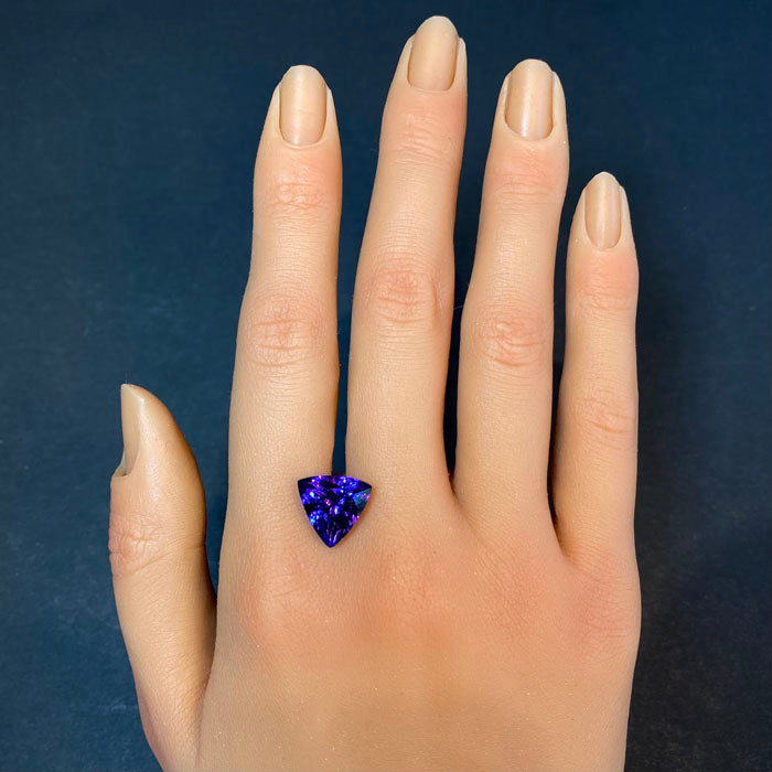 tanzanite gemstone on hand trilliant cut